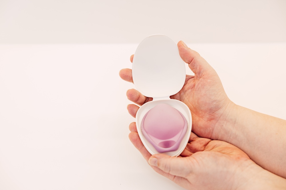 Hand hält ein Diaphragma zur Verhütung in seiner Aufbewahrungsdose
